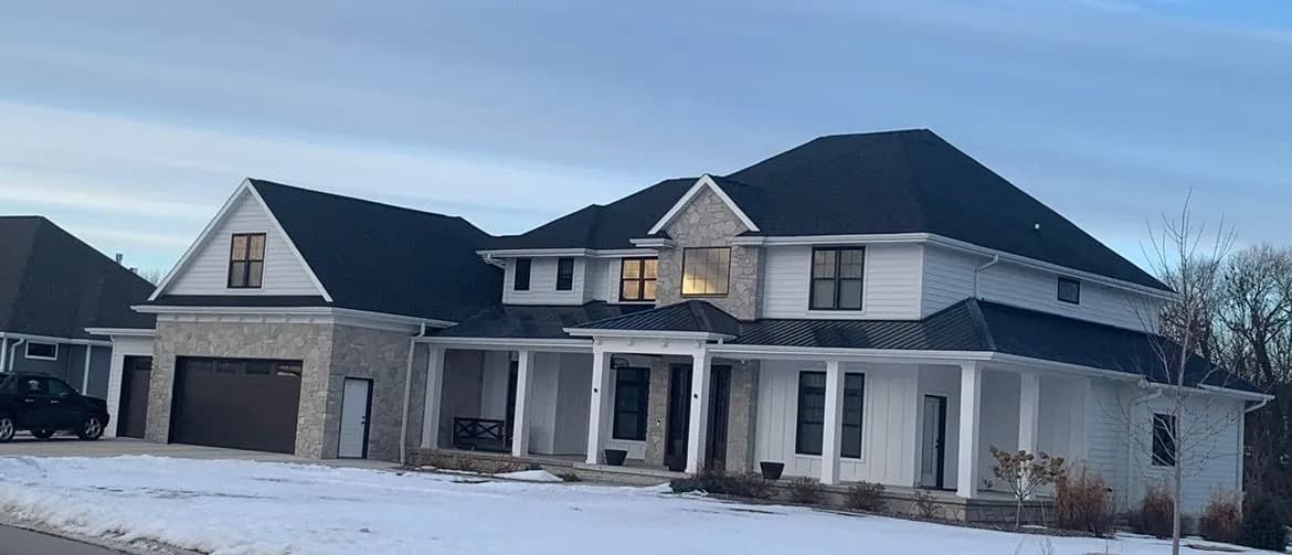 Large new construction home with bold black shingle roof installed by Pierce Roofing in Green Bay Wisconsin